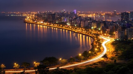 Fototapeta premium A panoramic view of the Necklace (Marine Drive) at night, with city lights reflecting on the water