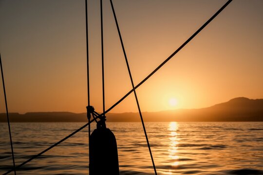 Sunset from a boat (sailboat) in the Mediterranean Sea with the Sierra Bermeja mountain in the background, in summer in Estepona, Malaga, Spain