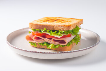 Close-up of two sandwiches with bacon, salami, prosciutto and fresh vegetables on rustic wooden cutting board. Club sandwich concept