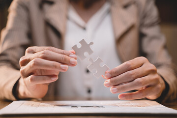 Close-up of business hands connecting jigsaw puzzle, success and goal achievement, the last jigsaw...