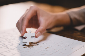 Close-up of business hands connecting jigsaw puzzle, success and goal achievement, the last jigsaw...