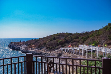 Obraz premium Aerial panorama of Thailand's verdant, with blue and aquamarine the sea, and clouds shining by sunlight in the background.