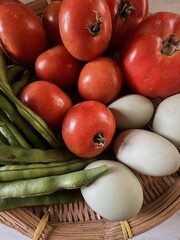 Close up of Basket of local produce from farmers market, green beans, tomatoes and duck eggs