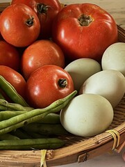 Close up of Basket of local produce from farmers market, green beans, tomatoes and duck eggs