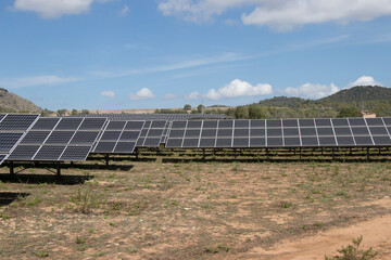Photovoltaic park in a rural area of the island of Mallorca, with blue sky and some white clouds.