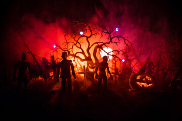 Scary view of zombies at cemetery dead tree, moon, church and spooky cloudy sky with fog, Horror Halloween concept.