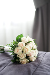 A beautiful bouquet of white roses in the room on the sofa.