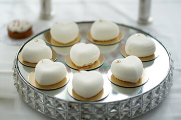 A buffet table with dessert cakes on a glass stand.