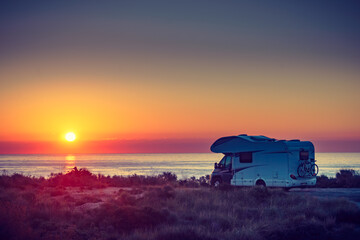 Caravan on sea at sunrise.