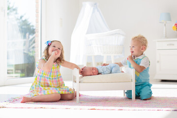 Kids play with newborn baby brother