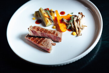 Close up food styling of a white plate of wagyu beef steak with grilled vegetable 