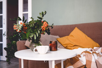 A Cozy Living Room Featuring a Soft Blanket, Lush Green Plants, and a Warm Cup of Coffee