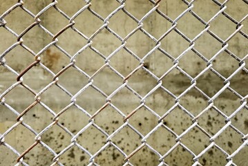 Fototapeta premium Wire fence with cement wall background.