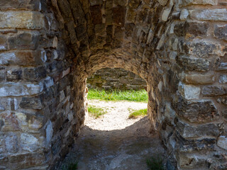 Stone walls of an ancient castle with a passage. Light at the end of the tunnel. Find a way out of difficulties