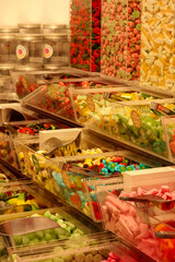 
colorful jelly candies are stacked in glass shelf boxes at the market