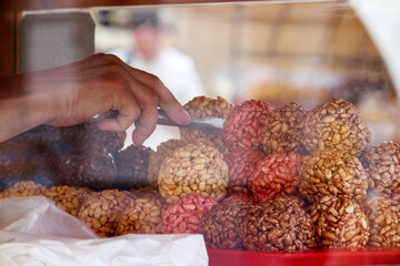 
Human hand with round cookies on display table behind glass wall