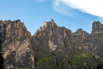 Breathtaking mountain peaks rise under a clear blue sky in the Dolomites during a sunny summer afternoon