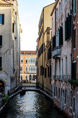 Charming narrow canal in Venice with picturesque buildings and a classic bridge on a sunny afternoon