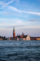 Fototapeta premium Captivating view of the Venetian skyline at sunset with historic architecture along the waterfront