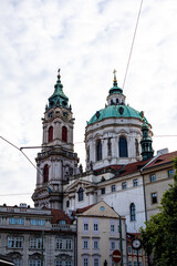 Fototapeta premium St. Nicholas Church in Prague showcasing its impressive Baroque architecture under a cloudy sky during the afternoon