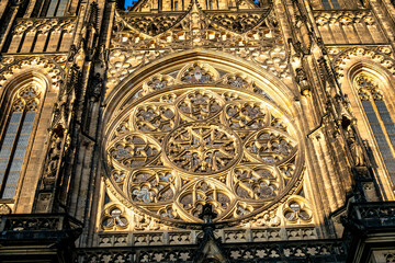 Intricate Gothic architecture of St. Vitus Cathedral in Prague showcasing a stunning rose window at sunset
