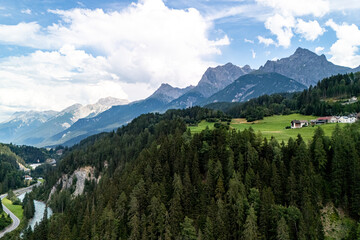 Scenic view of mountains and lush green valleys in the Alps during daylight with clouds in the sky