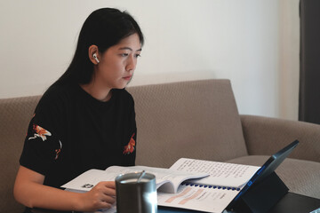 Female young Thai language teacher, college tutor coach looking at webcam and talking with students giving virtual teaching remote class, online lesson by zoom conference call on laptop or tablet.