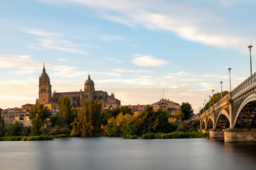 Fototapeta premium View of Salamanca (Spain) at sunset, with the cathedral and the Enrique Estevan bridge from the viewpoint of the pier on the Tormes river