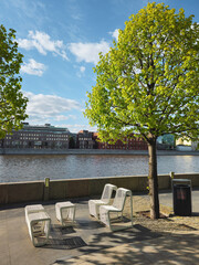 Moscow river embankment with chairs, table and green trees