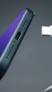 Close-up of type C wire for charging phone. Action. Type-C connector for charging phone on isolated ofn. New wire type C and included for phone