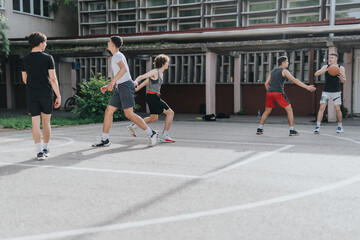 Friends engage in a spirited game of basketball on an old neighborhood court, capturing the essence of teamwork and fun under the sun.