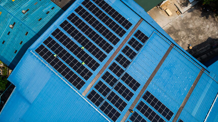Aerial top view of engineer worker installing solar photovoltaic panels system on roof of the factory, Electric power industry renewable energy. © winnievinzence