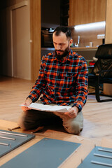 Focused handyman reading instructions assembling furniture at home