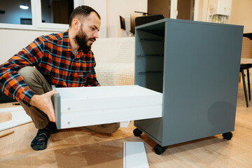 Handyman assembling furniture using instruction manual at home