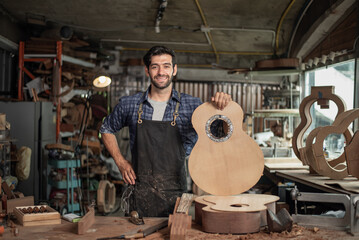 Portrait of guitar luthier small business owner in workroom