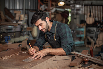 Luthier making a peghead of classical guitar