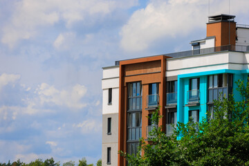 City view on a sunny day. Modern building and houses against the blue sky.