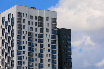 City view on a sunny day. Modern building and houses against the blue sky.