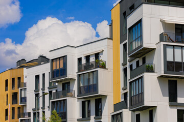 City view on a sunny day. Modern building and houses against the blue sky.