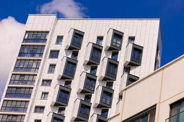 Cityscape on a summer day, modern buildings and houses against the blue sky 