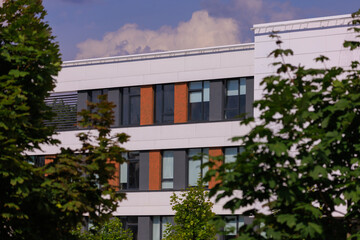 City view on a sunny day. Modern building and houses against the blue sky.