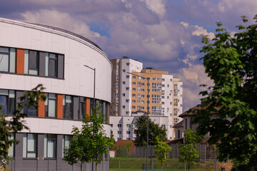 City view on a sunny day. Modern building and houses against the blue sky.