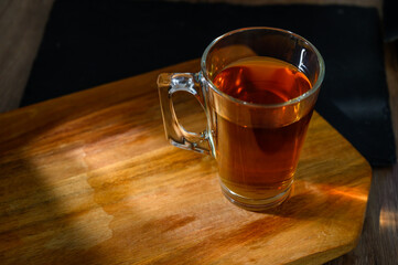 A classic glass cup of tea stands on a table
