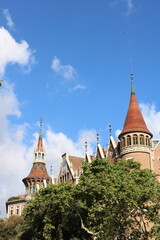 Torres en un edifico estilo castillo con un cielo azul de fondo