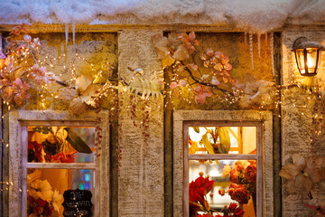 New Year's decorations, toys and garlands on the windows in fabulous scenery. Houses for children in a public place. Background for design. 