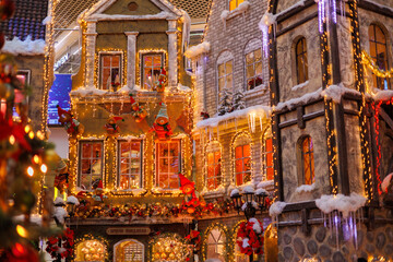 New Year's decorations, toys and garlands on the windows in fabulous scenery. Houses for children in a public place. Background for design. 