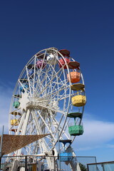 Rueda de la fortuna junto a un cielo azul, parque de diversiones en Barcelona