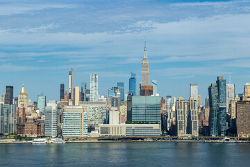 Obraz premium A panoramic view of the New York City skyline featuring the Empire State Building on a clear day near the East River