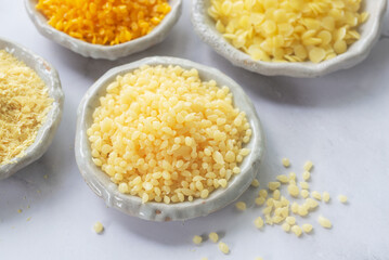 Candelilla wax  in white ceramic plate on white marble background.