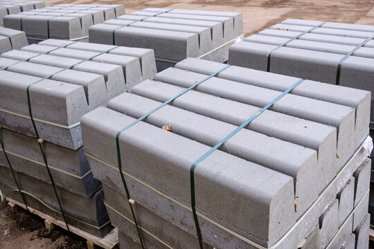 Stack of packed border stones for asphalt road on wooden pallet